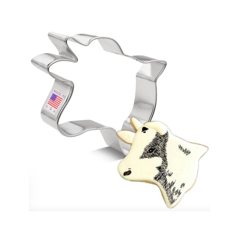 Metal cow cookie cutter with decorated cow with horns cookie with black shading 