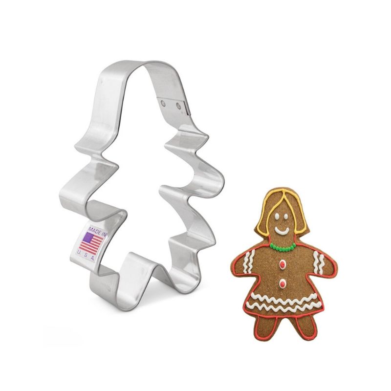 Metal cookie cutter in the shape of a Gingerbread girl with hair and decorated cookie with icing on brown cookie