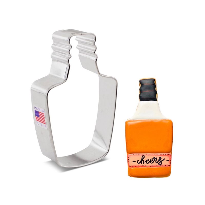 Stainless steel liquor bottle cookie cutter beside bottle of whiskey in orange colour and black lid with cheers written on label