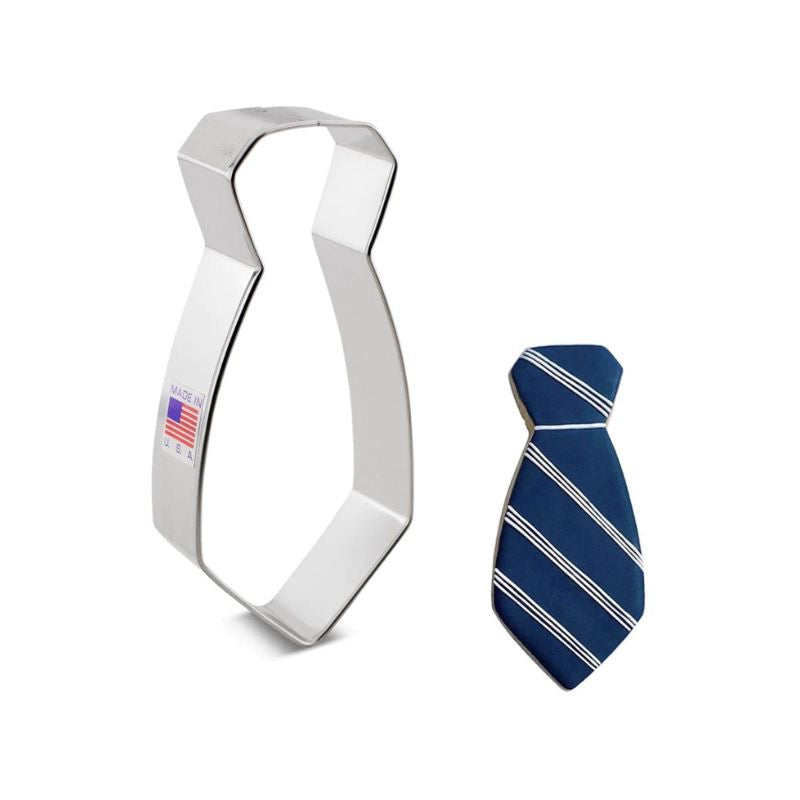 Stainless steel cookie cutter with Made in USA and flag sticker on stick and beside decorated mans neck tie with navy blue icing and white stripes