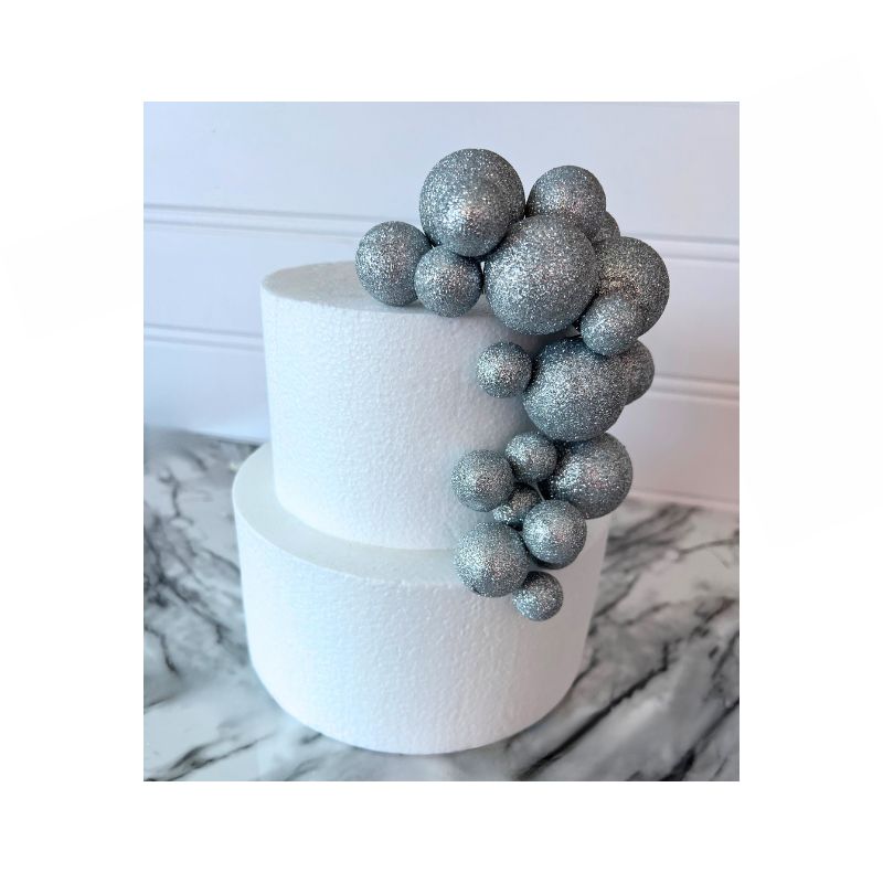 2 tiered white cake with multi sized silver glitter cake balls