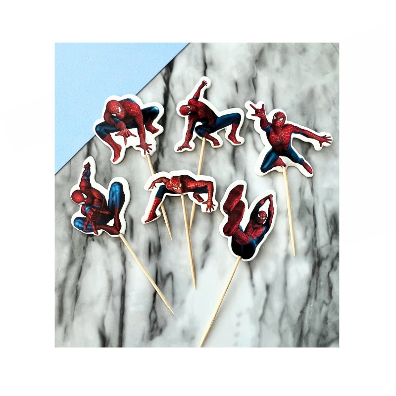 Six Spiderman Cupcake Toppers featuring Spider-Man in various action poses, each attached to a wooden stick, are placed on a marble surface. The Spider-Man figures are shown swinging, crouching, and jumping, displaying dynamic and iconic superhero stances.