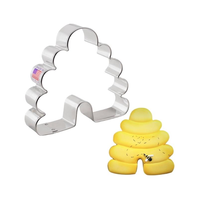 Stainless steel cookie cutter used for cutting out bee hive shaped cookies and is decorated with yellow royal icing and bees