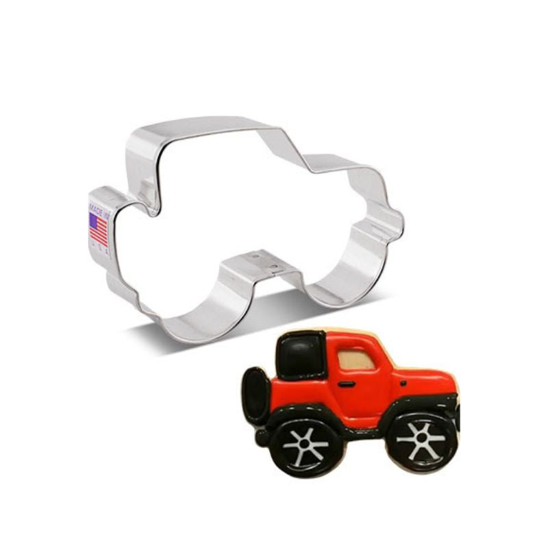 Stainless steel cookie cutter in the shape of a jeep with made in the USA and American flag sticker on side and jeep cookie with red and black icing