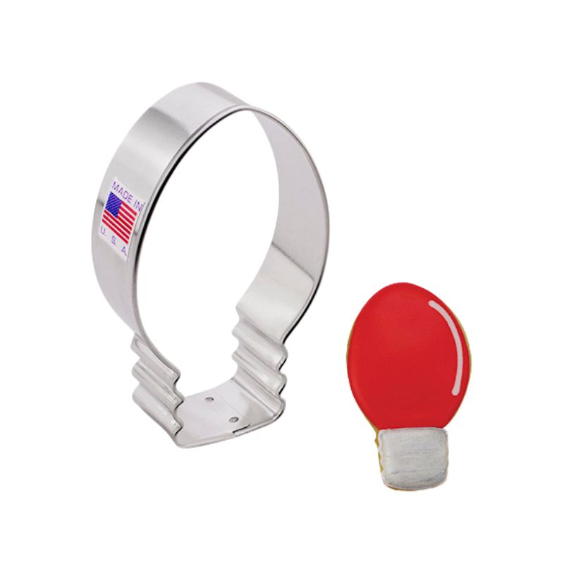 Christmas bulb cookie cutter made in the USA with sticker of flag and second cookie beside in the shape of a Christmas light bulb in red and silver royal icing