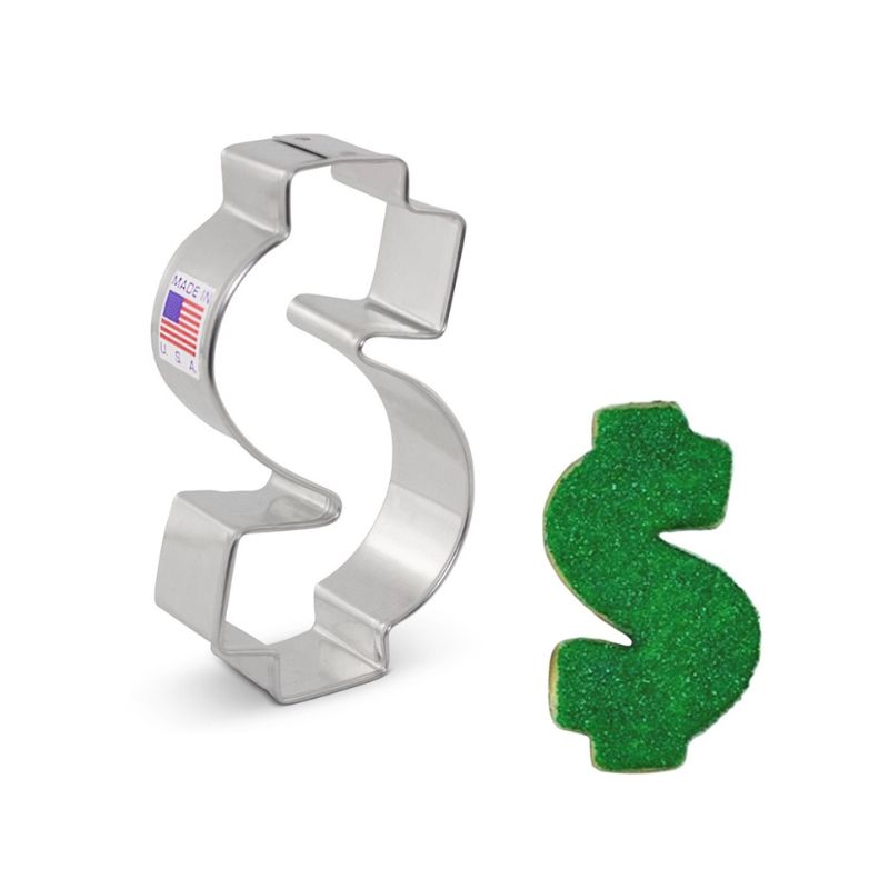 metal cookie cutter in the shape of a money symbol with sticker of American flag beside a money sign green royal icing sugar cookie with sanding sugar on top