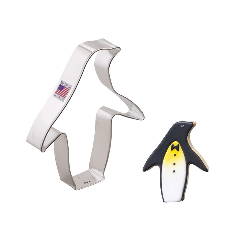 Lg penguin metal cookie cutter that is made in the usa with American flag sticker and penguin decorated beside its black white and yellow royal icing details