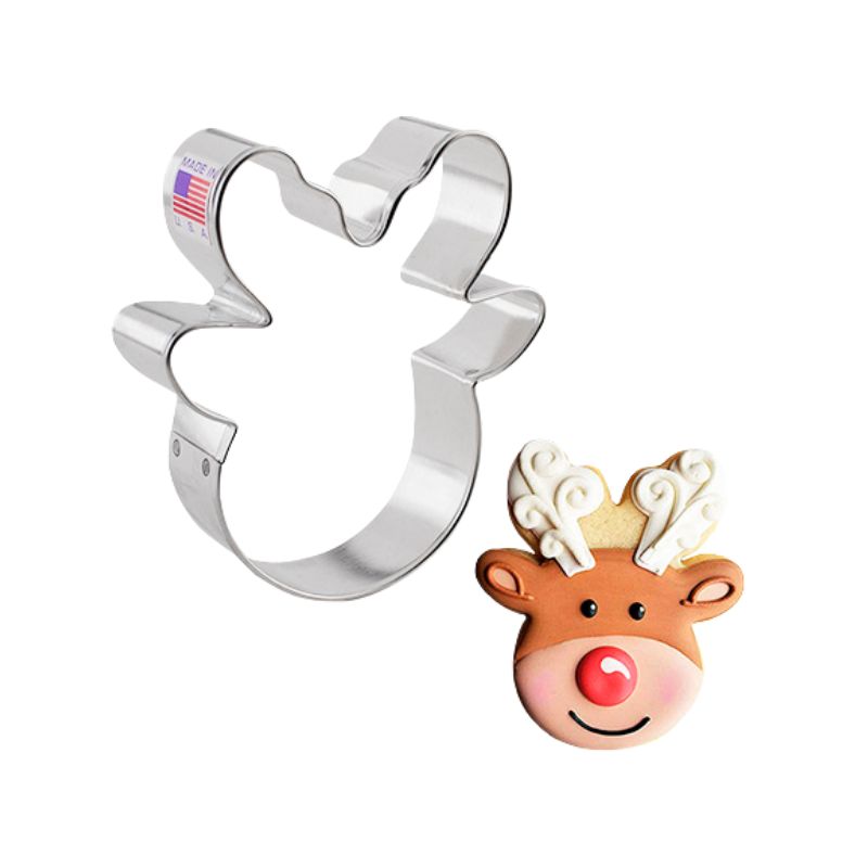 Christmas reindeer cookie cutter made of metal and beside a decorated with royal icing cookie brown colour with red nose and antlers