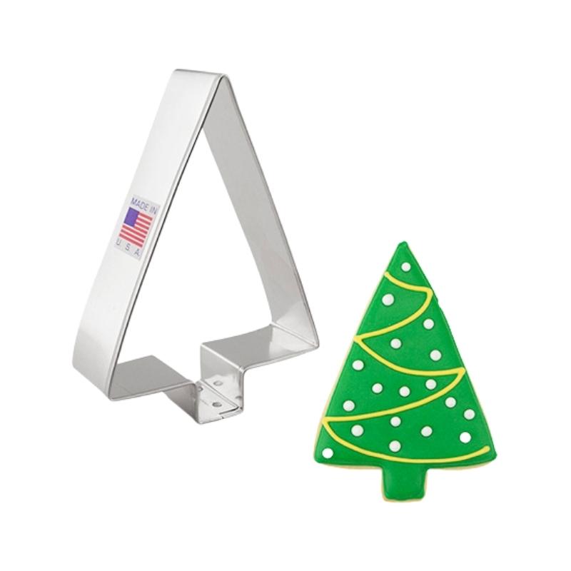 Metal cookie cutter with a made in the USA American flag cookie cutter in the shape of a simple tree with no branches and beside a green crhristmas tree with white polka dots and yellow lines