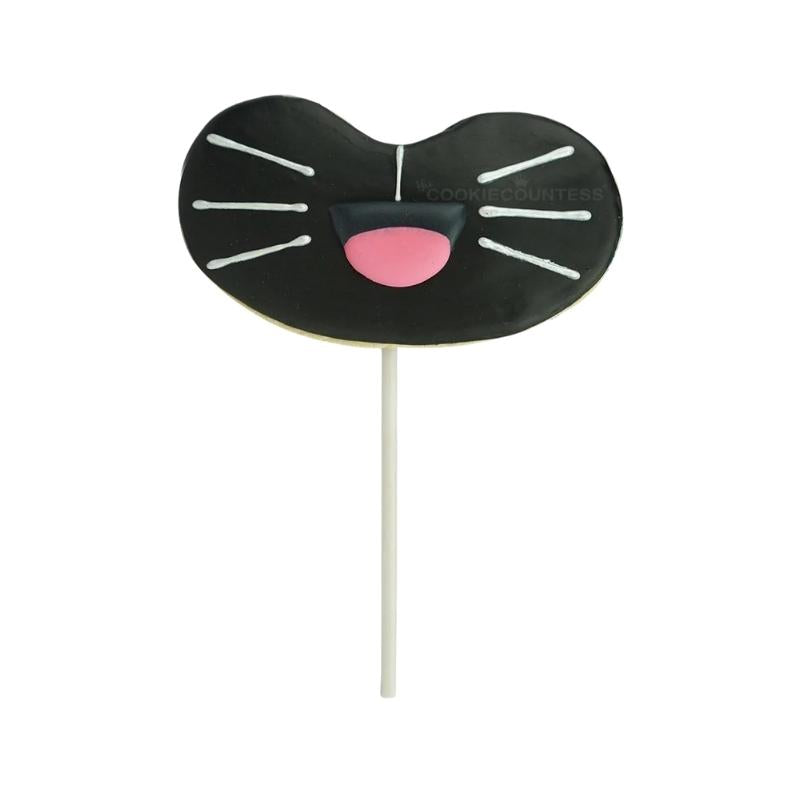 black cookie on a stick with whiskers and pink nose